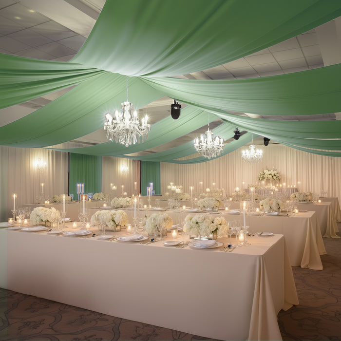 Elegant banquet setup with green drapery, chandeliers, and floral centerpieces.