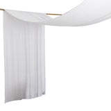 White fabric draped on a wooden rod in a studio setting.