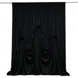 Black draped fabric curtain backdrop with elegant gathered folds