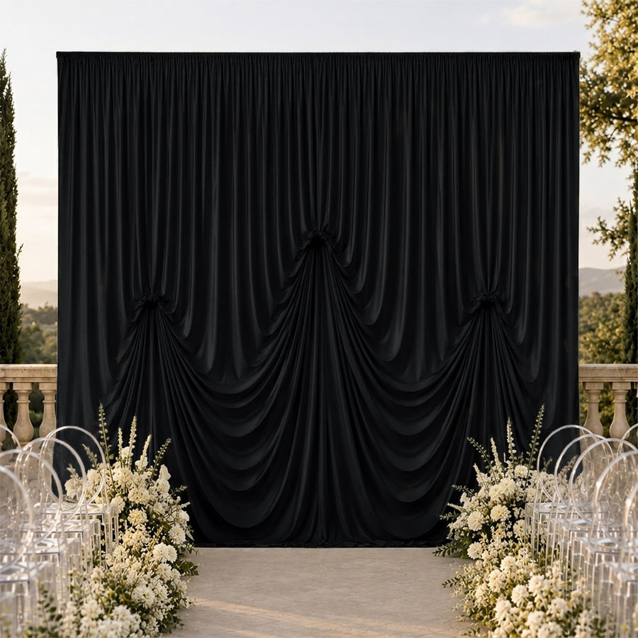 Elegant black draped wedding backdrop with white floral aisle decor outdoors