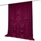 Elegant burgundy velvet curtain draped on a rod against a white background