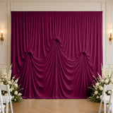 Elegant magenta draped wedding backdrop with white floral arrangements