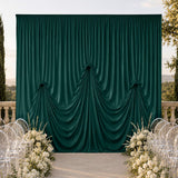 Outdoor wedding backdrop with emerald green draped curtain and floral aisle decor