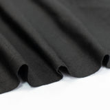 Black fabric texture with soft draping folds.