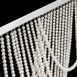 Close-up of elegant pearl strands draping from a silver frame.