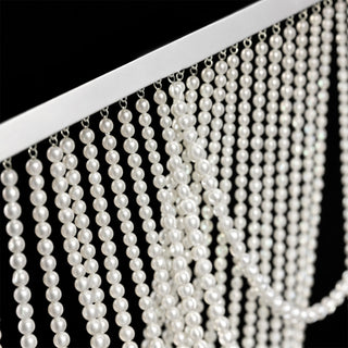 Close-up of elegant pearl strands draping from a silver frame.