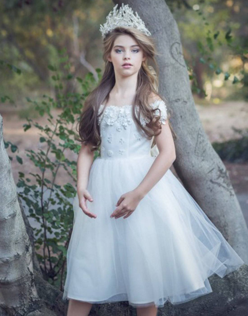 Girl in white dress with crown outdoors