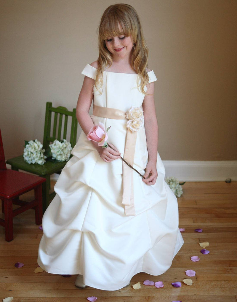 Young girl in white dress with sash and flower