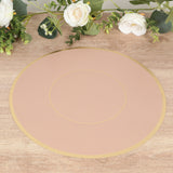 Round blush pink placemat with gold trim on a wooden surface.