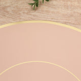 Pink round placemat with gold trim on a wooden surface.