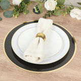 Elegant black and white dinner plate setting with a napkin and gold ring.