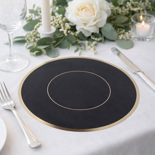 Elegant black placemat with gold accents on a beautifully set dining table.