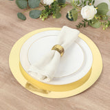 Elegant white plate with gold rim and linen napkin on wooden table.
