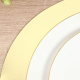 Elegant white plate with gold rim on textured wood background.