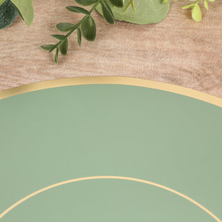 Green plate with gold rim on textured surface with greenery accents.