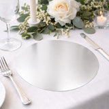 Elegant round silver placemat on a beautifully set dining table.