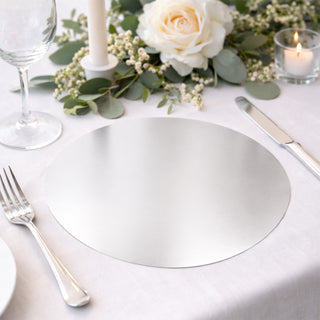 Elegant round silver placemat on a beautifully set dining table.