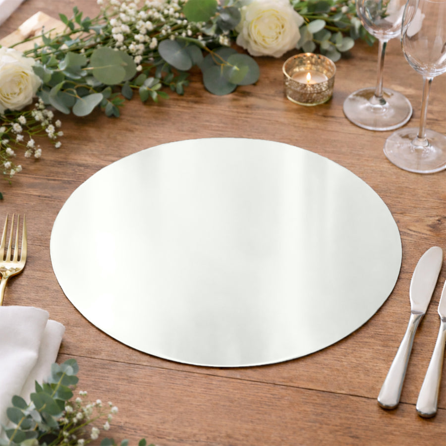 Elegant round mirror placemat on a rustic wooden table with floral accents.