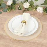 Elegant table setting with white plates, gold accents, and a napkin holder.