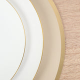 Elegant white and gold rimmed plates stacked on a textured wood surface.