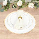 Elegant dinner plate set with a beige napkin and gold ring on a wooden table.