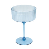Blue ribbed glass dessert bowl on a plain white background. #whtbkgd