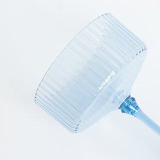 Blue ribbed glass on a plain backdrop.