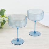 Blue ribbed glass dessert bowls on a wooden surface.