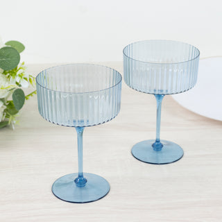 Blue ribbed glass dessert bowls on a wooden surface.