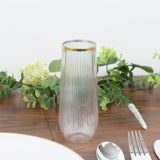 Elegant ribbed glass vase with gold rim, styled with greenery.