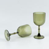Green ribbed glassware set on white backdrop