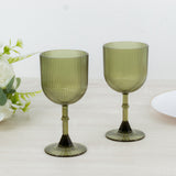 Green ribbed glassware set on a wooden table with decorative elements.