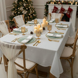 Elegant holiday dining table set with candles and festive decor.