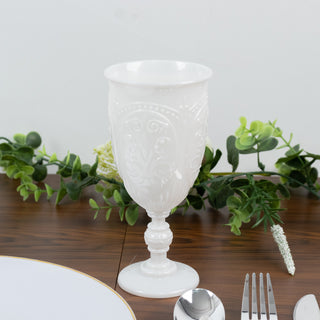 Elegant white decorative glass on a dining table with greenery accents.