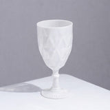 White geometric patterned glass goblet on a plain background.