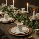 Elegant dinner table setting with floral cups, plates, and candles.