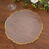 Clear decorative plate with a ruffled gold edge on a wooden table.