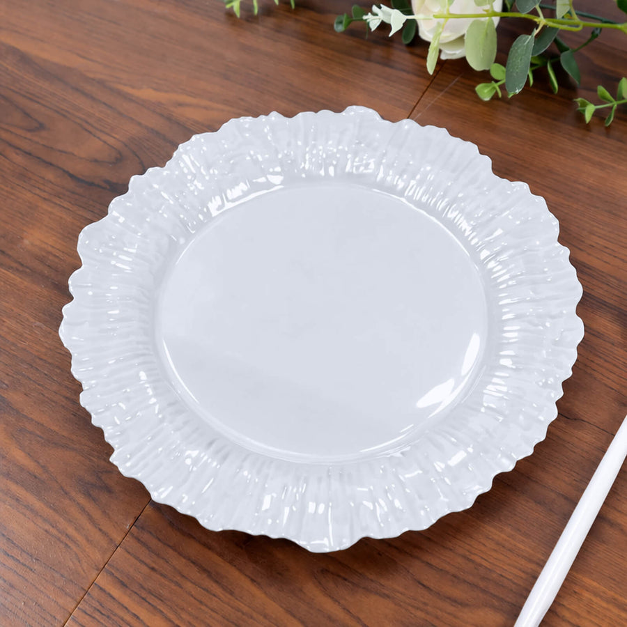 White decorative plate with a ruffled edge on a wooden surface.