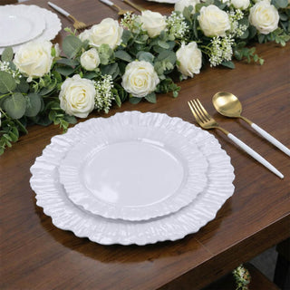 Elegant white ruffled dinner plates set on a wooden table with floral decor.