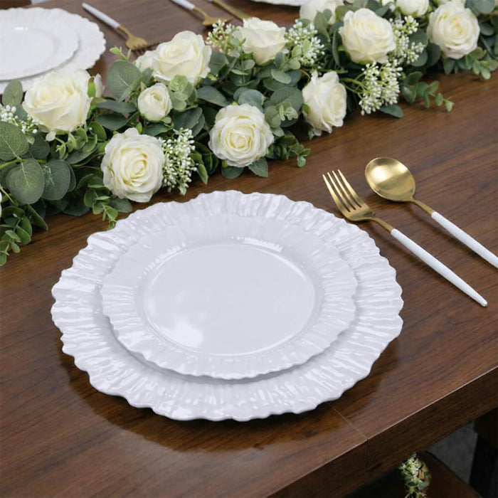 Elegant white ruffled dinner plates set on a wooden table with floral decor.