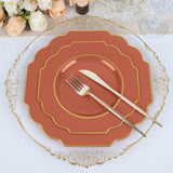 Elegant coral and gold dinnerware set with fork and knife on a table setting.