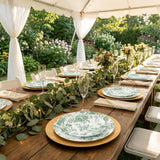 Outdoor garden wedding table setting under a white canopy with floral plates

