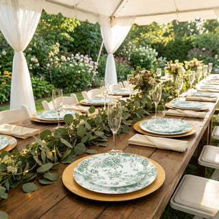Outdoor garden wedding table setting under a white canopy with floral plates
