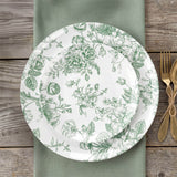 Green floral patterned plates on rustic wood table setting with gold flatware