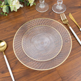 Elegant clear glass plate with gold rim on a wooden table setting.