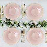 Elegant pink plates arranged with cutlery and greenery on a marble surface.