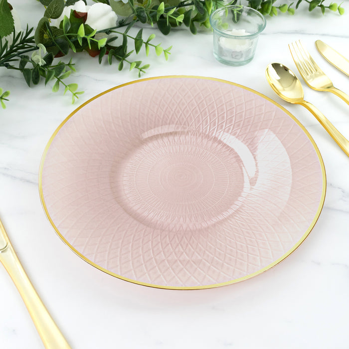 Pink patterned plate with gold rim on marble table, surrounded by greenery.