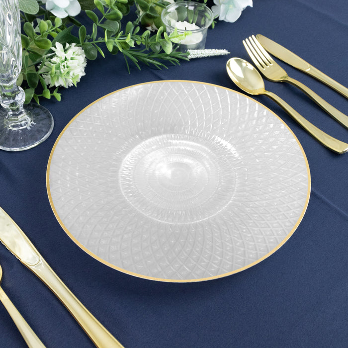 Elegant clear glass plate with gold rim on a navy table setting.