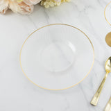 Clear decorative plate with gold rim on a marble surface.