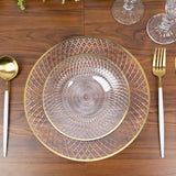 Elegant clear glass plates with gold rim on a wooden table setting.